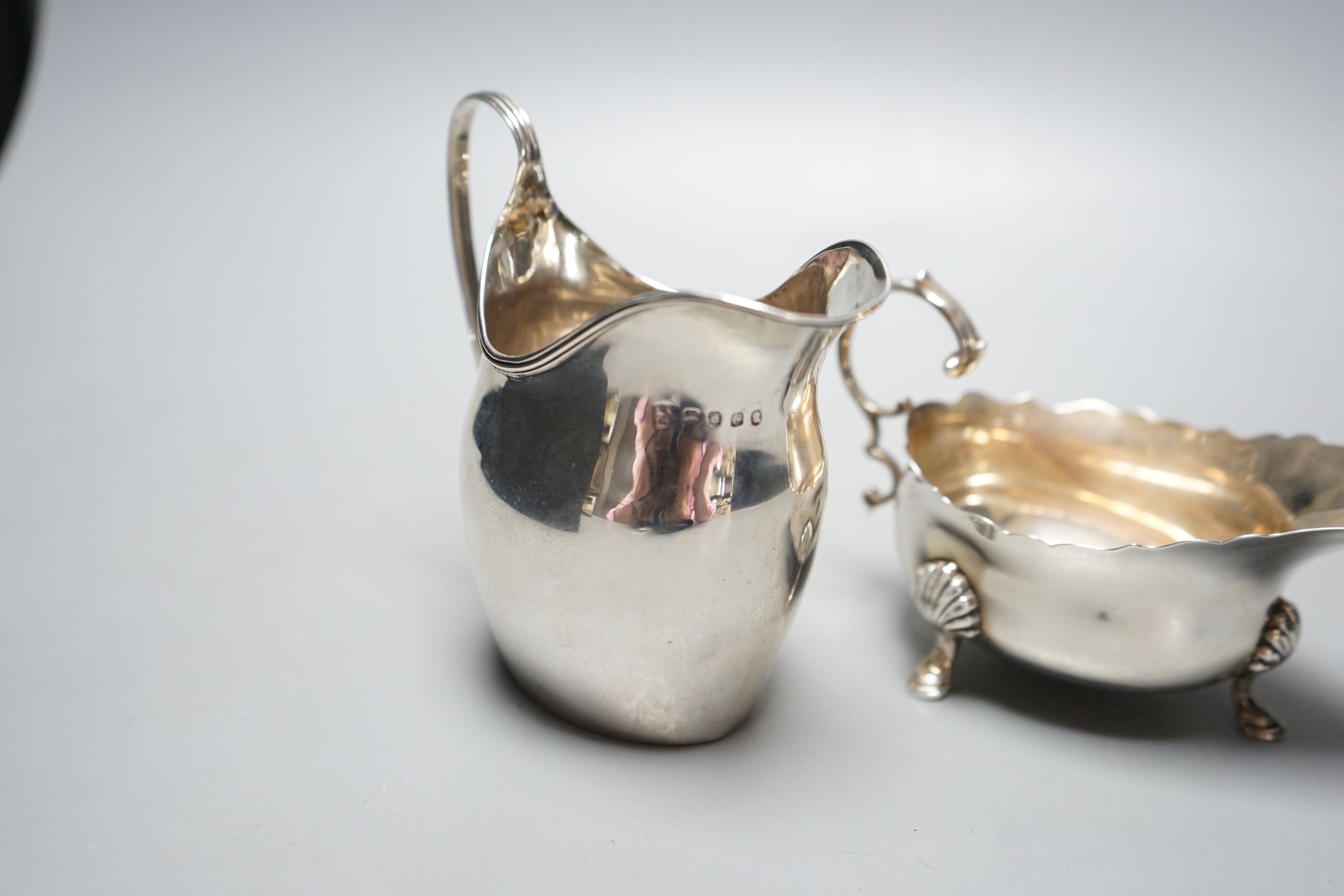 A George III silver jug, London, 1798, a silver sauce boat and pair of silver mounted dwarf candlesticks.